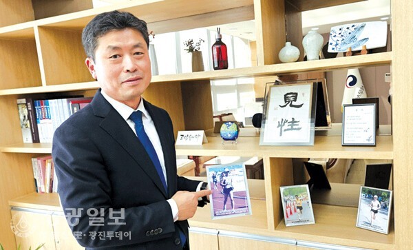 마라톤 자신을 들고 있는 이은규 서장. 사진속에는 철학적인 견성, 향기 시가 있는 액자는도 있다