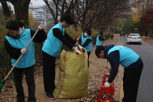 지난 24일 신천지 서울교회 성도들이 중랑천변에서 낙엽 치우기 봉사활동을 하고 있다.