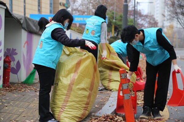 지난 24일 신천지 서울교회 성도들이 중랑천변에서 낙엽 치우기 봉사활동을 하고 있다.